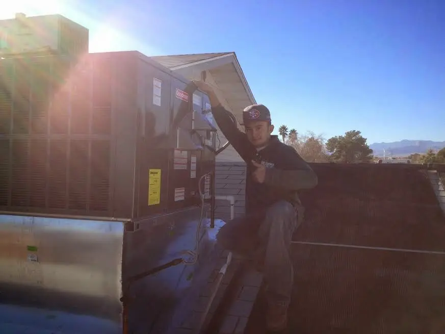 HVAC technician performing Boiler Repair on a rooftop unit in Glenarden